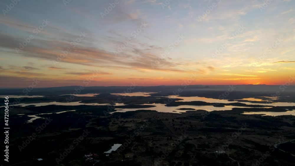 Bright yellow sun on horizon during sunrise over Alqueva river, Portugal. Aerial sideways Bright yellow sun on horizon during sunrise over Alqueva river, Portugal. Aerial sideways