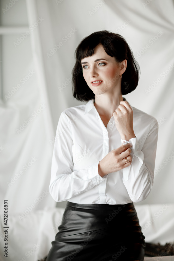 Confident happy attractive business woman. elegant Girl in white shirt and leather skirt sitting at home office. Confident happy attractive business woman. elegant Girl in white shirt and leather skirt sitting at home office.