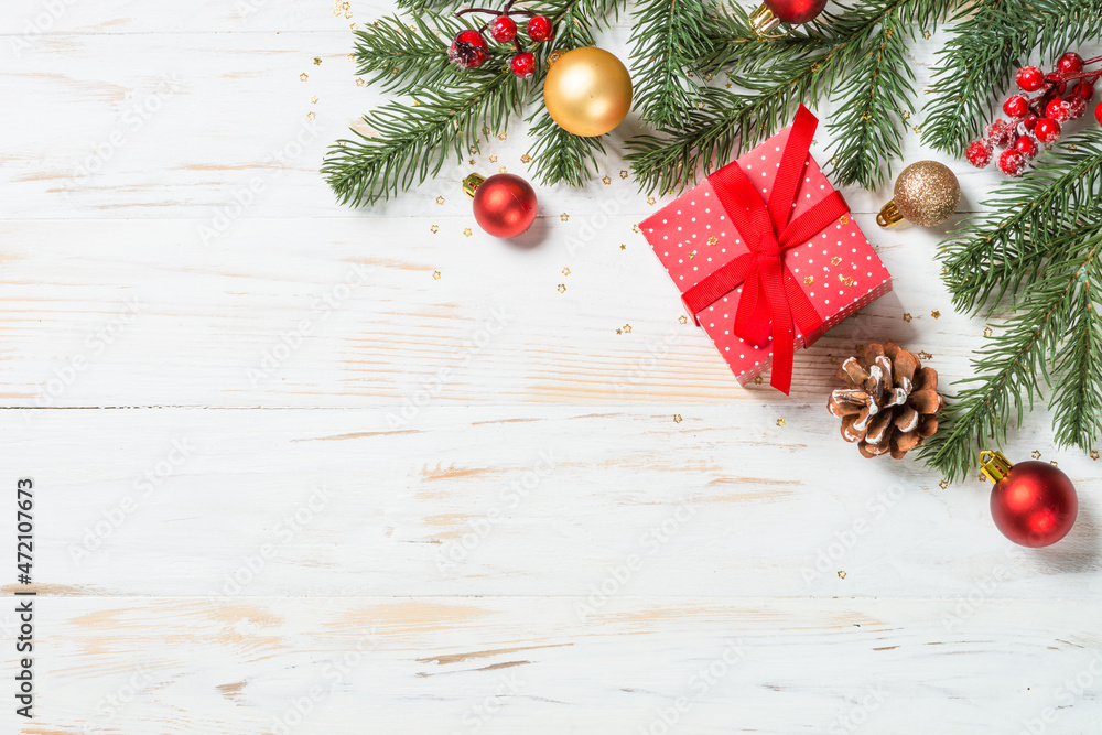 Christmas present box with red ribbon and holiday decorations. Top view at white wooden table with copy space. Christmas present box with red ribbon and holiday decorations. Top view at white wooden table with copy space.