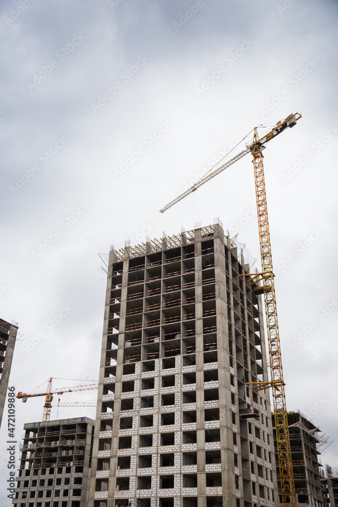 Construction of a multi-storey building. A high-rise crane on the construction of a multi-storey building.