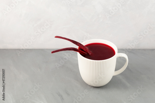 Salgam or fermented beet juice in white cup. Popular Turkish drink. Selective focus, copy space photo