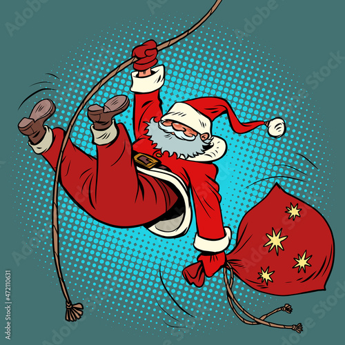 Santa Claus descends on a rope with gifts. Christmas and New Year winter holidays