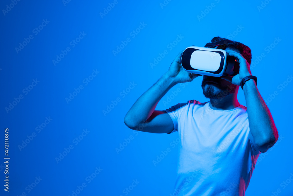 Vitrual reality concept. Man are playing a game in virtual reality. Young man in VR glasses are gaming with realistic holograms in simulator. Entertainment and leisure concept. Modern technologies.
