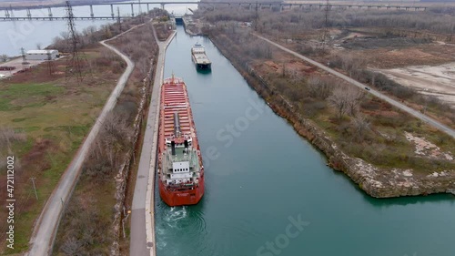 Two cargo ships maneuver inside the Beauharnois Canal in the St Lawrence Seaway, near Montreal, Quebec. High quality 4K aerial view. photo