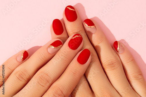 Womans hands with fashionable red manicure close up. Christmas new year nail design