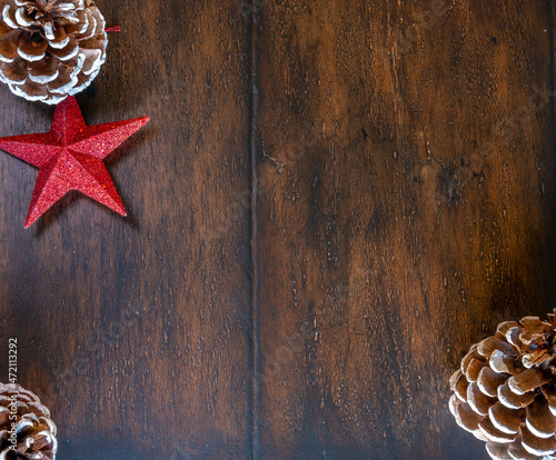 Top View of Single Red Star on Wooden Table With 3 White Tip Pine Cones