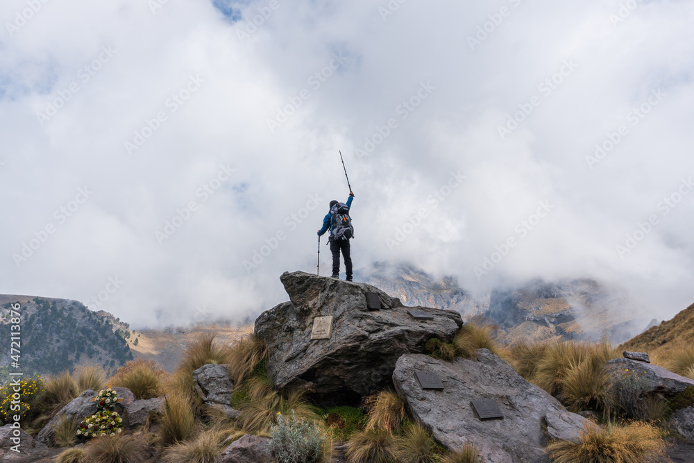 Happy hiker winning reaching life goal, success, freedom and happiness, achievement in mountains.