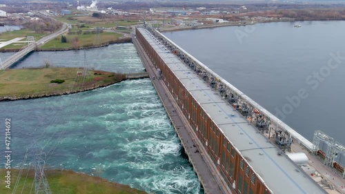 High quality, 4K aerial view of a hydroelectric generating station and distribution power lines.