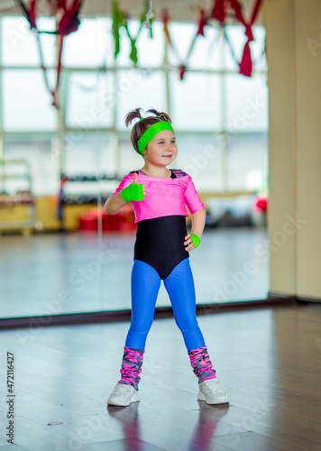 a small, beautiful girl,doing sports in the gym,in bright, colored sportswear