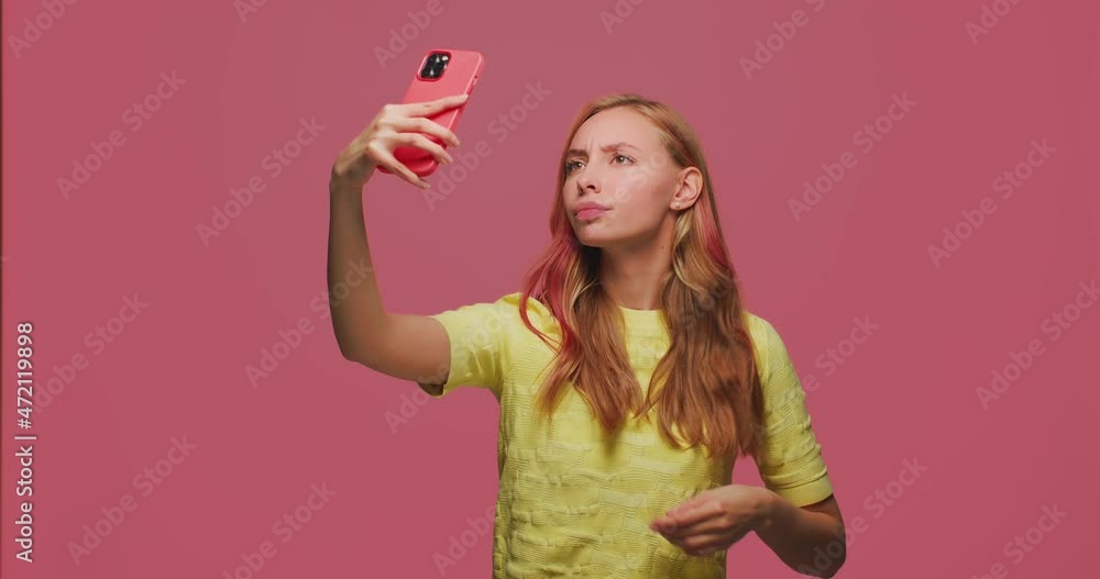Beautiful young girl beauty blogger posing, making selfie photo on phone, preening, smiling, looking at camera Beautiful young girl beauty blogger posing, making selfie photo on phone, preening, smiling, looking at camera