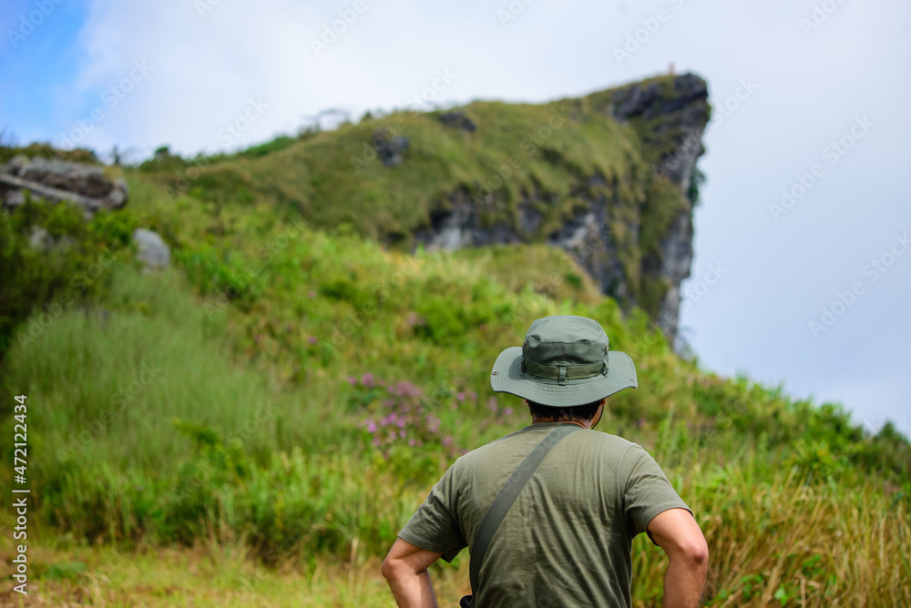A trekker stands looking at the path on the mountain to travel. A trekker stands looking at the path on the mountain to travel.
