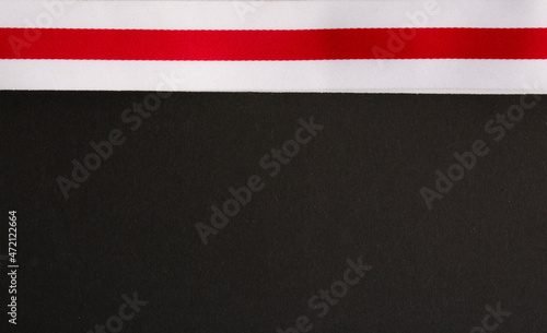 red and white ribbon on black background