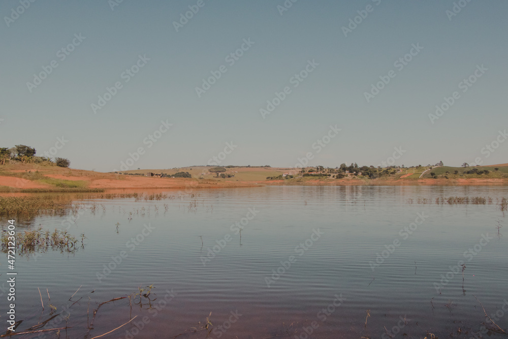calm blue sky and lake with land in the horizon