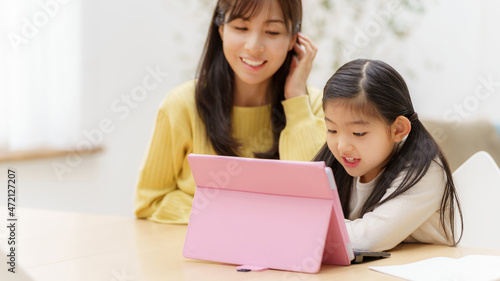 タブレットを使って学習する女の子とお母さん