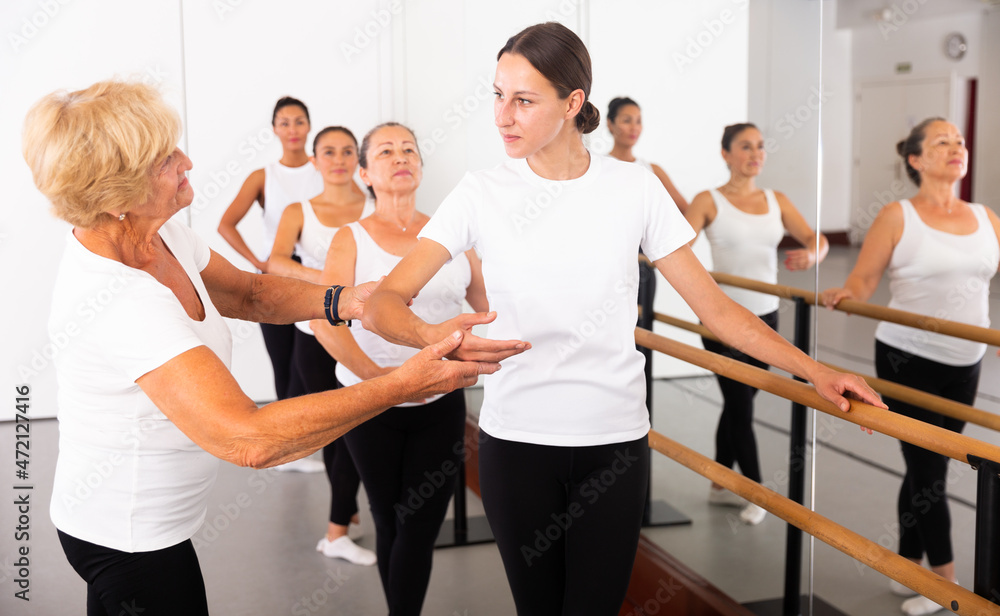 © JackF - Elderly female ballet instructor adjusting students form © JackF - Elderly female ballet instructor adjusting students form