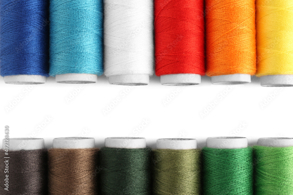 Set of colorful sewing threads on white background, flat lay. Space for text Set of colorful sewing threads on white background, flat lay. Space for text