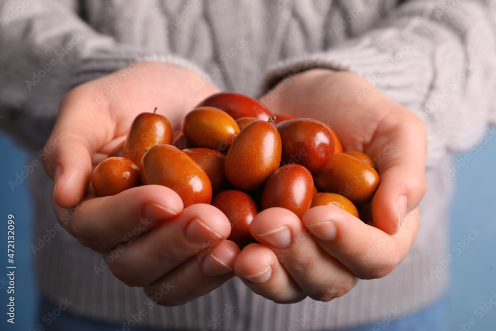 Woman with handful of fresh Ziziphus jujuba fruits, closeup Woman with handful of fresh Ziziphus jujuba fruits, closeup