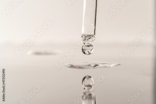 The texture of serum or oil with a pipette on a grey background. photo