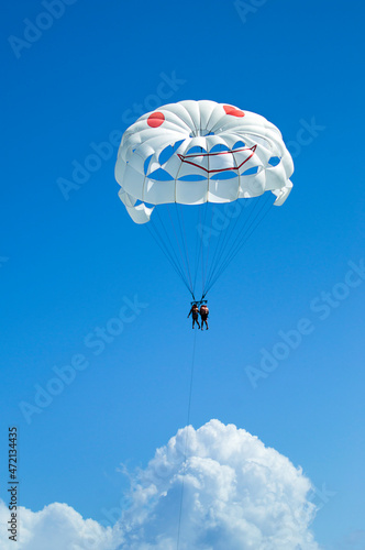 White smiling parasailing above clouds at Caribbean sea