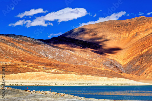 Reflection of Mountains on Pangong tso (Lake) with blue sky in background. shared by China and India along India China LOC border and extends from India to Tibet. Leh, Ladakh, Jammu and Kashmir, India