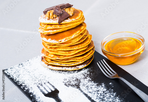 Homemade breakfast sweet pancakes with honey, chocolate and walnuts photo