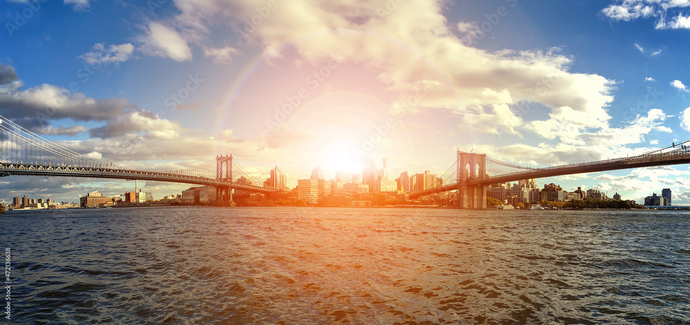 Sunlight shining over the downtown Brooklyn skyline between the Manhattan and Brooklyn Bridges in New York City