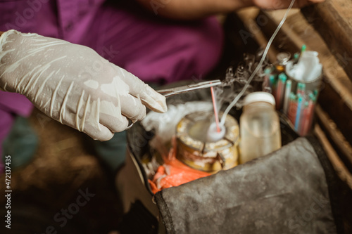 hand preparing the tools for artificial insemination of cow.