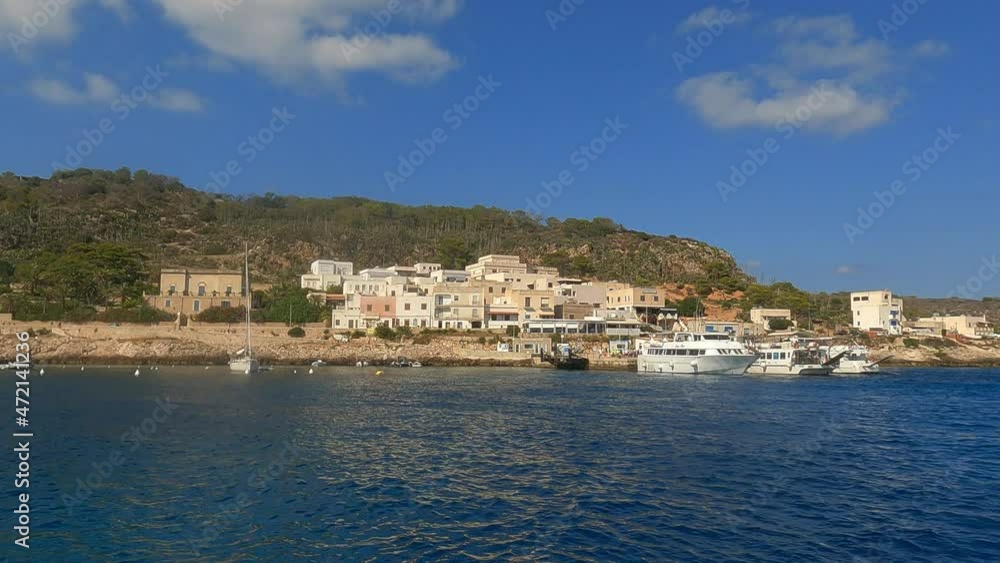Panning view of Levanzo Sicilian fishing village and waterfront scenic bay with moored boats in foreground, Sicily in Italy. Slow-motion Panning view of Levanzo Sicilian fishing village and waterfront scenic bay with moored boats in foreground, Sicily in Italy. Slow-motion