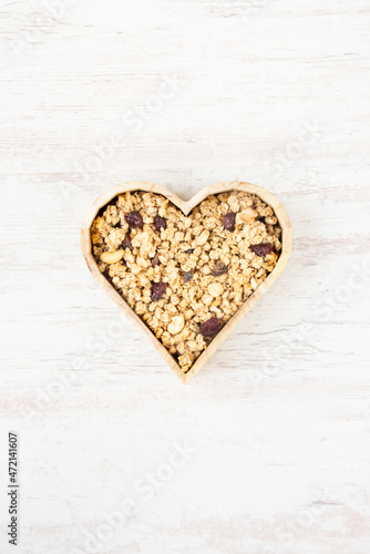 Obraz na płótnie Top view of a heart shaped bow full of crunchy granola. Healthy eating concept. w salonie