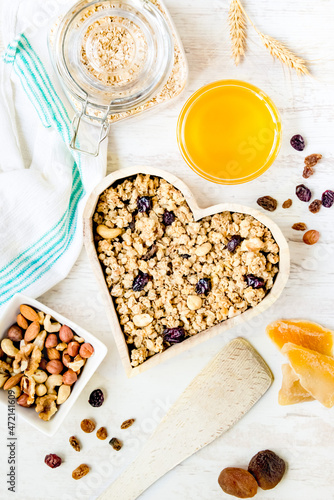 Obraz na płótnie Top view of a heart shaped bow full of crunchy granola. Healthy eating concept. w salonie