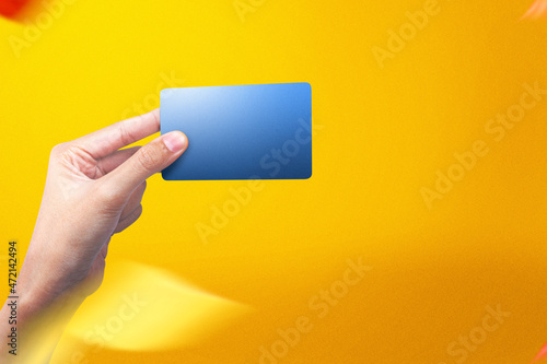 Hand holding an empty blue card with a colored background