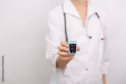 Pulse oximeter with hand of doctor isolated on white. The concept of portable digital device to measure person's oxygen saturation. Measuring oxygen saturation, pulse rate and oxygen levels
