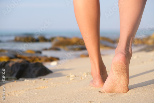 Feet and legs of women walking on Beach of the sea On weekends