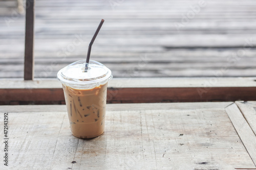 plastic glass of iced coffee with milk on blurred vintage background