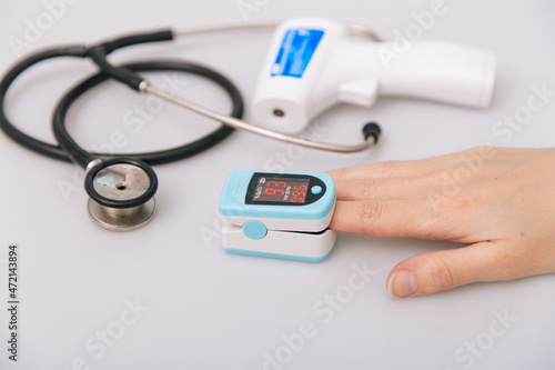 Stethoscope, pulse oximeter and thermometer gun on white background. Treatment of cold or flu. Phonendoscope. Infrared isometric thermometer gun to check body temperature for virus symptoms