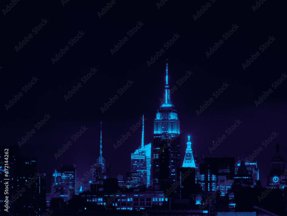 Blue lights of the New York City skyline buildings glowing against the empty night sky