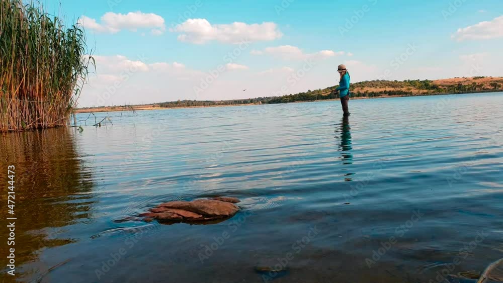 A girl fishing in a calm lake on a perfect spring day A girl fishing in a calm lake on a perfect spring day