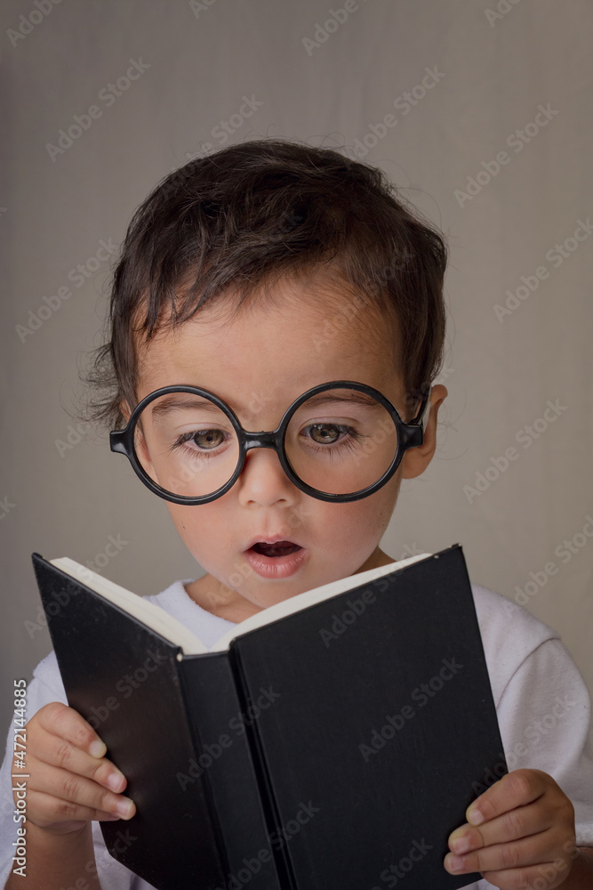 portrait of a little boy reading a black book portrait of a little boy reading a black book