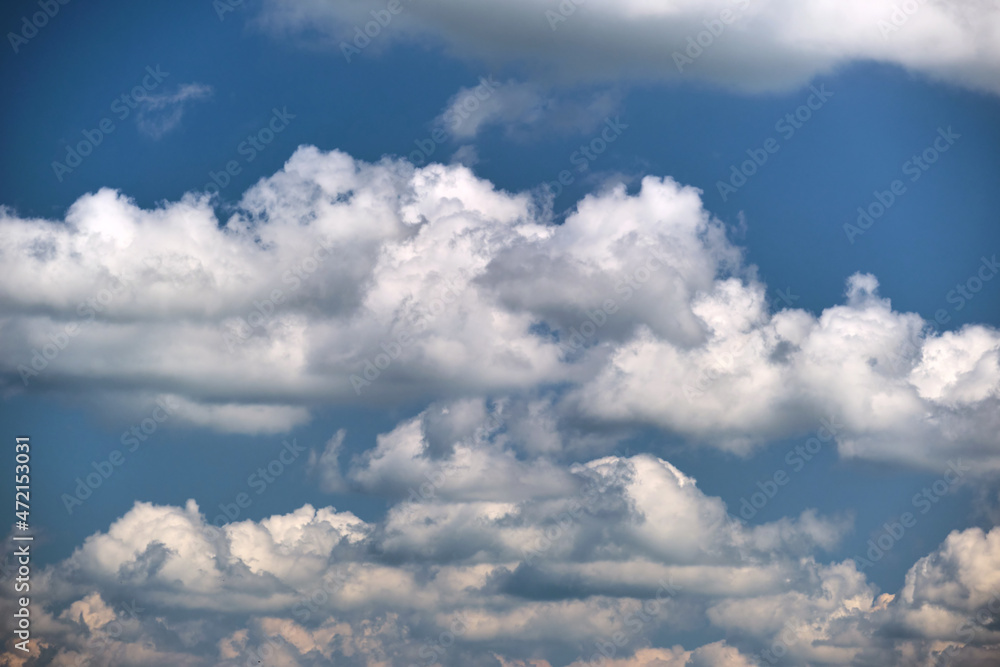 Bright landscape of white puffy cumulus clouds on blue clear sky Bright landscape of white puffy cumulus clouds on blue clear sky