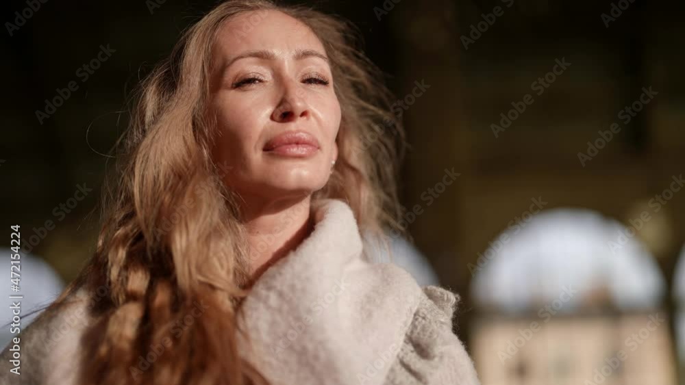 A close-up portrait of an adult stylish beauty with long white hair standing on the street. Human face, the perfect concept of natural skin makeup A close-up portrait of an adult stylish beauty with long white hair standing on the street. Human face, the perfect concept of natural skin makeup