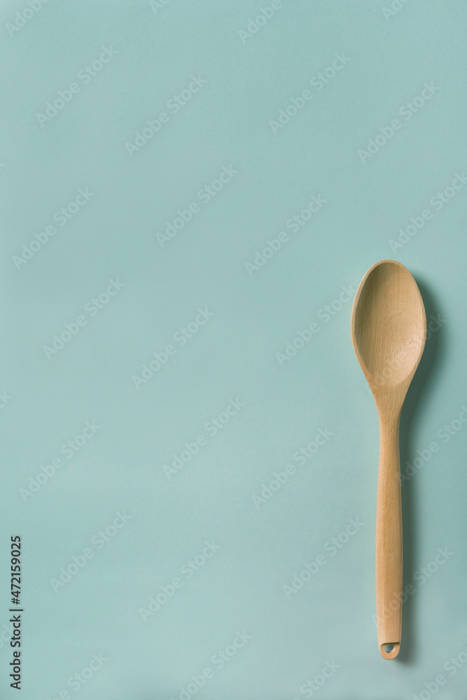Wooden kitchen spatula isolated on a blue background. Cooking concept. Wooden kitchen spatula isolated on a blue background. Cooking concept.