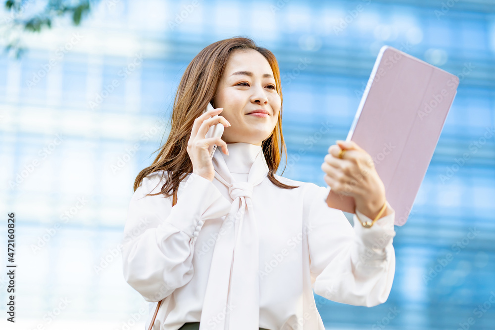 スマホで通話している笑顔の女性 スマホで通話している笑顔の女性