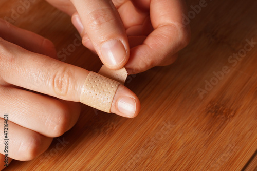 Female hands and a medical plaster on the finger