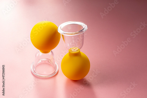 Wallpaper Mural Silicone cans for vacuum massage. Y ellow cans for massage on a pink background. Devices for vacuum massage skin care.  Torontodigital.ca