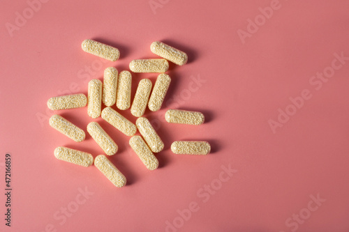 Magnesium capsules. Magnesium in transparent capsules with granules inside. Pills on a pink background. 