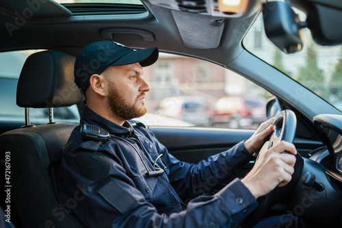 Foto Male police officer in uniform poses in the car