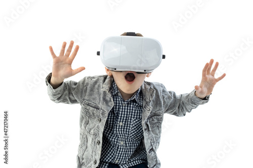 Young boy with virtual reality glasses isolated on white background. A child in emotional excitement wearing 3D glasses.