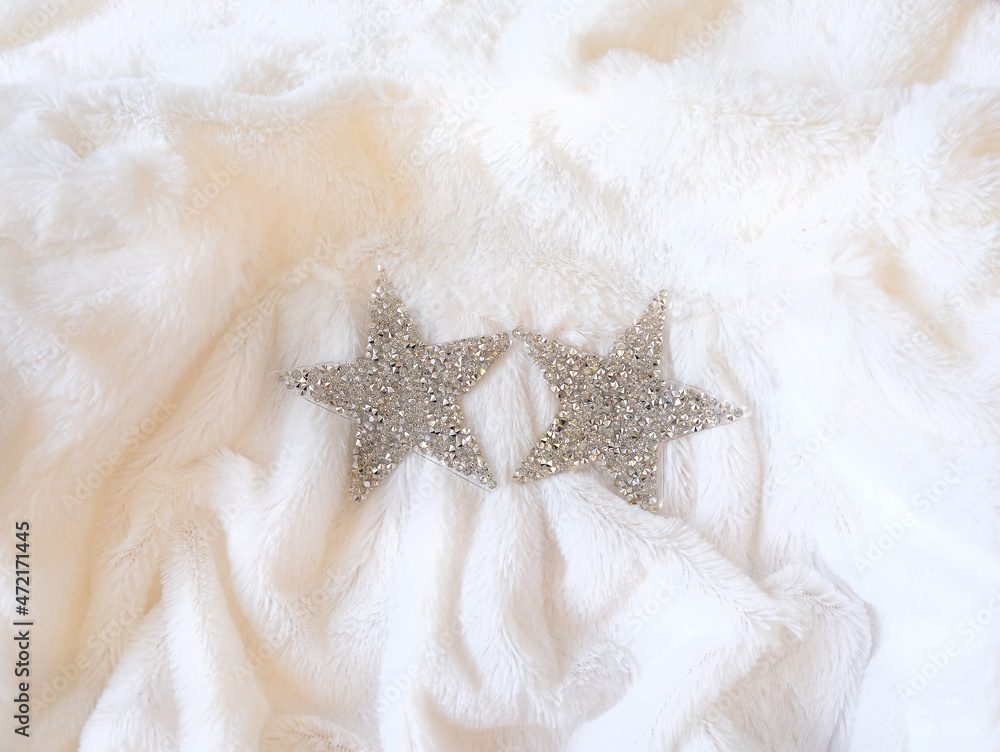 Two glitter silver stars on white fluffy background. Concept of celebrating new year. Christmas mood. Flat lay. Minimal holiday concept Two glitter silver stars on white fluffy background. Concept of celebrating new year. Christmas mood. Flat lay. Minimal holiday concept