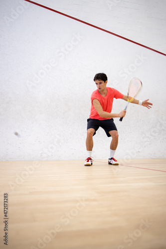 Squash player in action on a squash court (motion blurred image  color toned image) © lightpoet