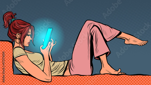 a young woman lies and watches a smartphone, the Internet and online social networks